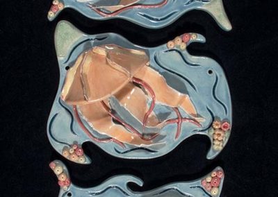 Three ceramic pieces with a blue background and 3D jellyfish on them.