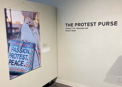 A print of the Protest Purse message and the title of the gallery with details on the wall.