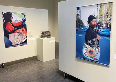 Two prints and a sculpture (purse) on display at the Protest Purse gallery.