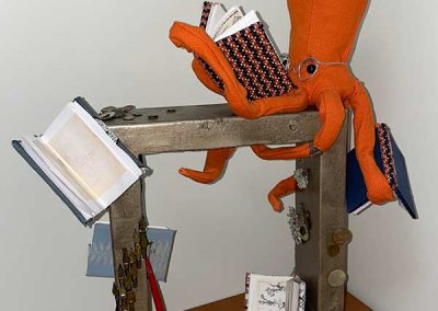 Abstract sculpture of a squid reading books.